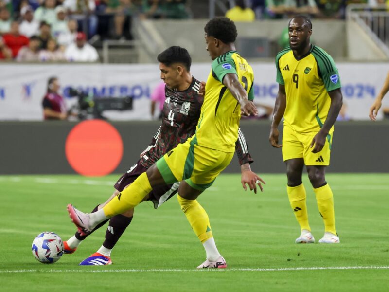 El delantero jamaiquino Demarai Gray fue registrado este sábado, 22 de junio, al intentar impedir un disparo del capitán mexicano, Edson Álvarez (i), durante el segundo partido del grupo B de la Copa América, en el NRG Stadium de Houston (Texas, EE.UU.). Álvarez salio lesionado al minuto 30. EFE/Leslie Plaza