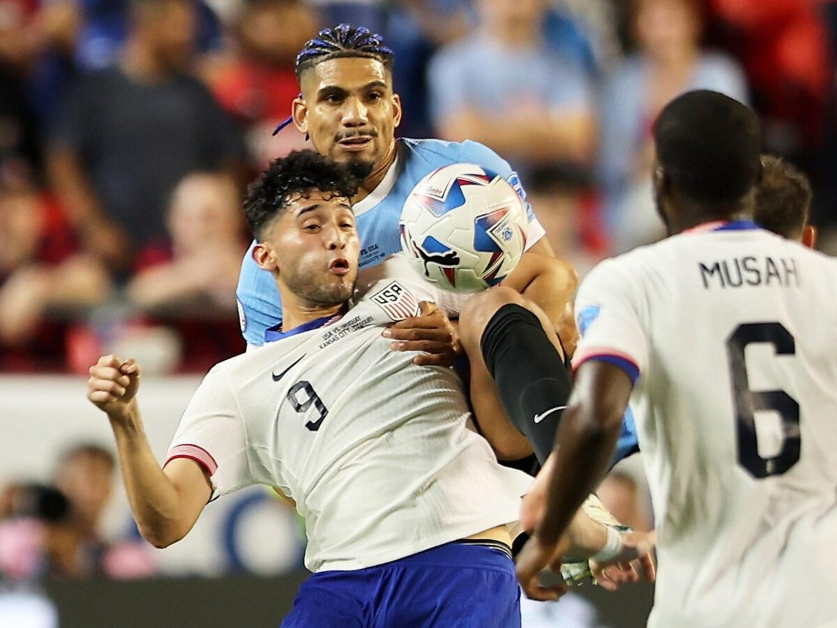 El defensa uruguayo Ronald Araujo (atrás) fue registrado este lunes, 1 de julio, al disputar un balón con el atacante estadounidense Ricardo Pepi, durante el partido final del grupo C de la Copa América 2024, en el estadio Arrowhead de Kansas City (Misuri, EE.UU.). EFE/William Purnell